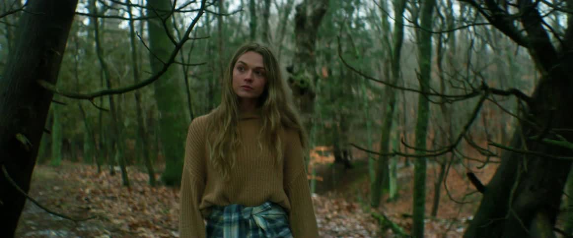 A woman is hiking through the forest