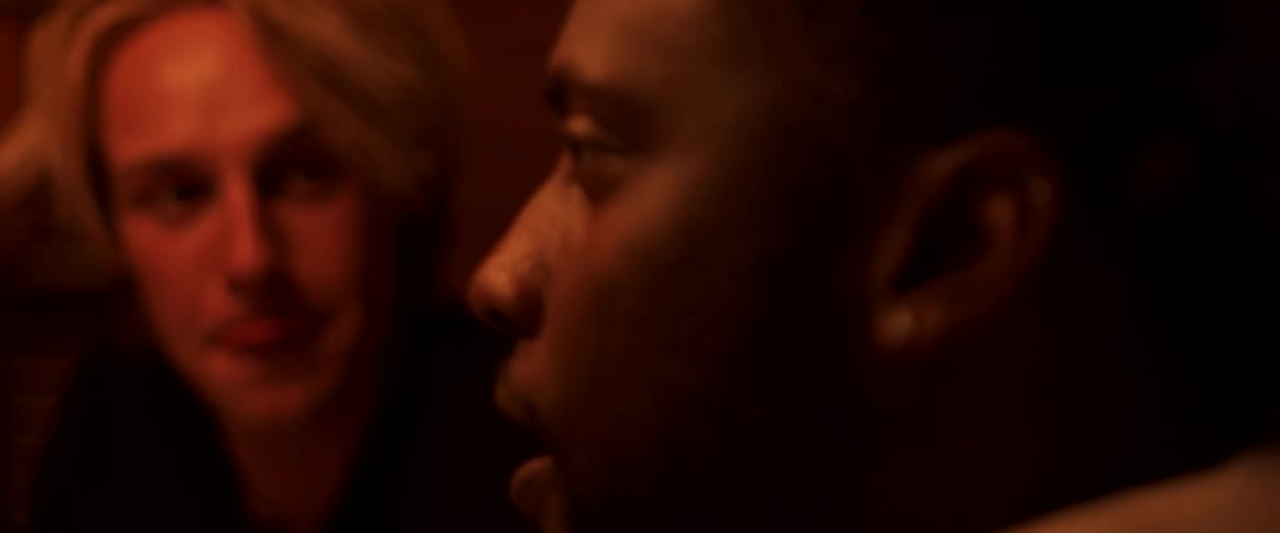 Two men near window smile and talk