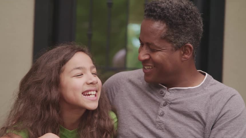Father and daughter happily talking outside the house