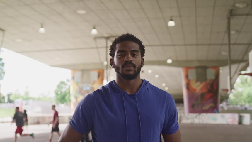 Man standing on a basketball court looking at the camera