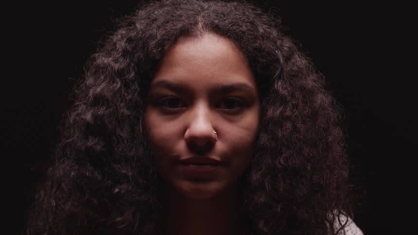 A woman looking up and staring in darkness