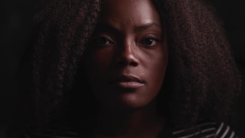 A black woman looks straight ahead