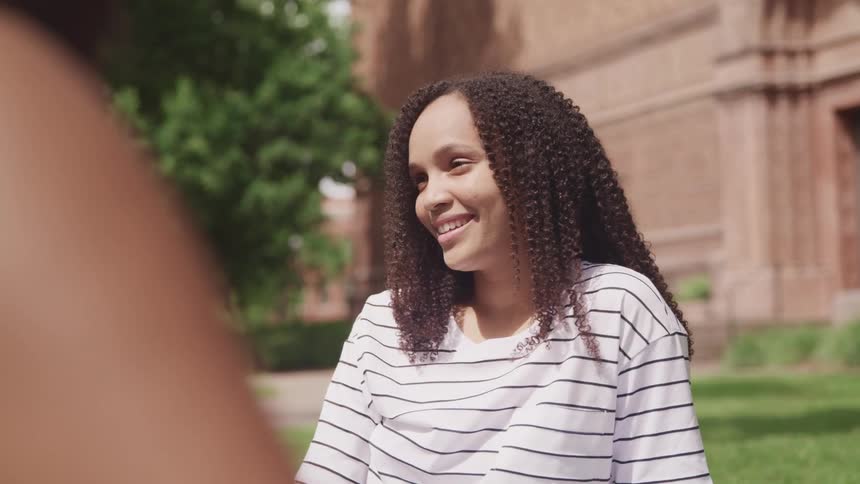A woman sitting outside and smiling while talking