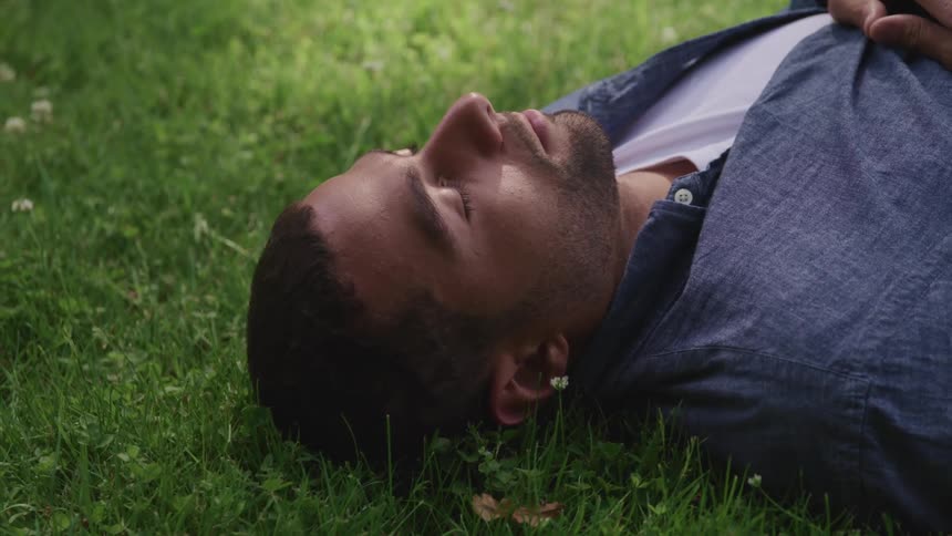 A man is sleeping in the grass