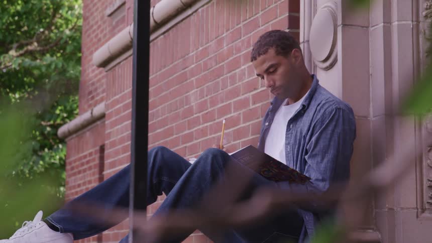 A man sitting outside reading