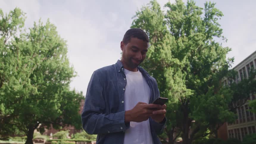 A man is using his cellphone by the building