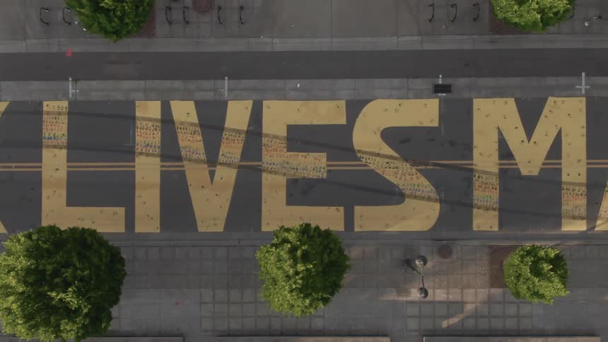 Black lives matter painted in yellow paint on a street