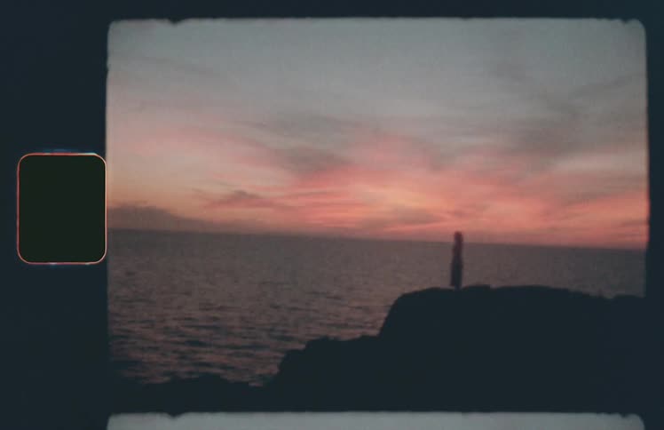 A woman standing on a cliff with the ocean in the background