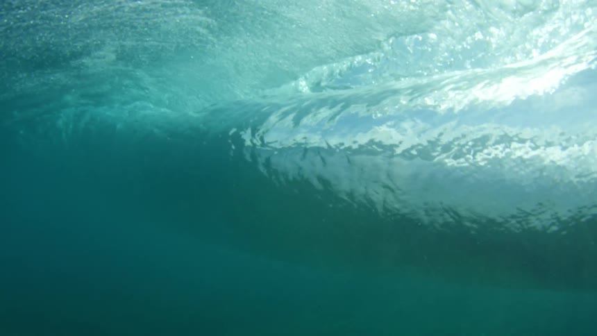 Underwater view of water rippling and the sun shining through