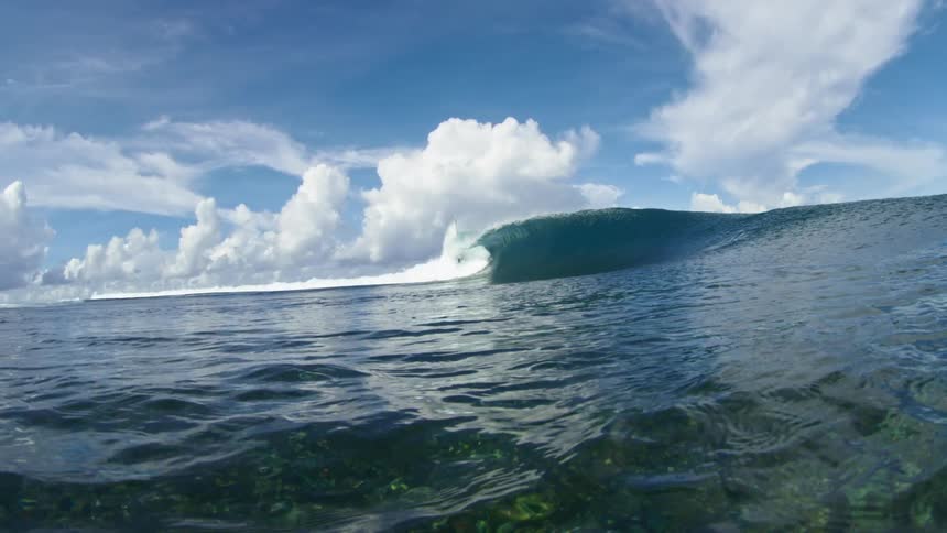 Huge wave rolls in under a cloudy sky