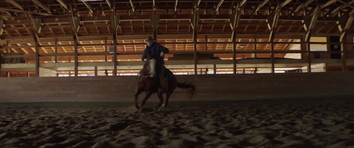 A man with a hat and jacket riding a horse
