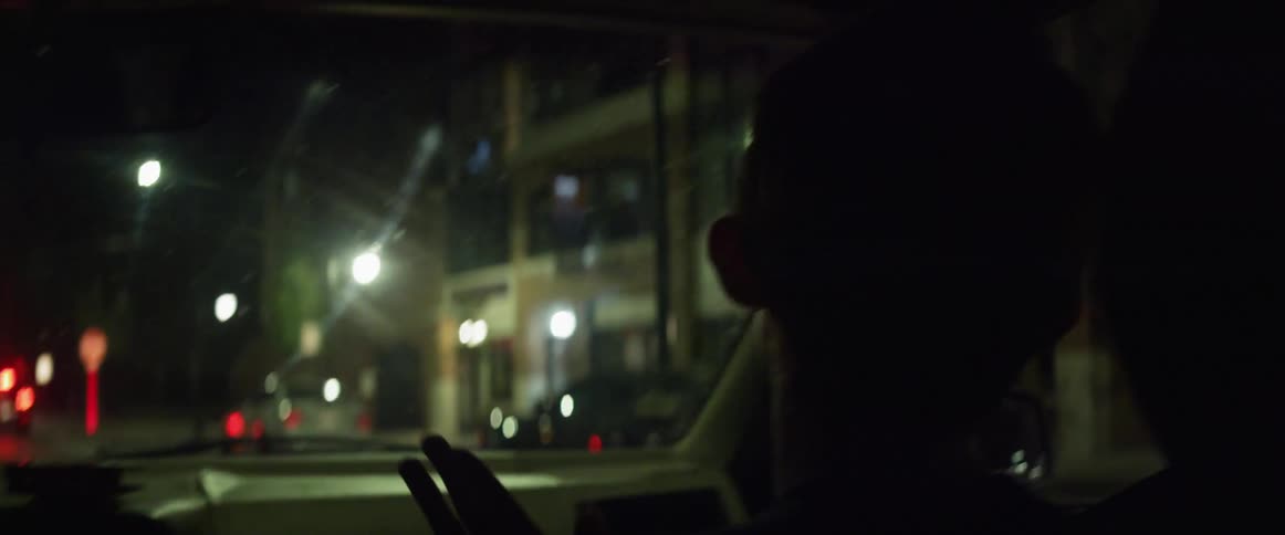 A passenger dancing while riding in a car at night