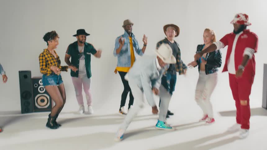 Group of young people energetically dancing in front of a white background
