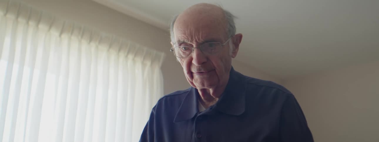Elderly man checks slideshow slides by hand at home