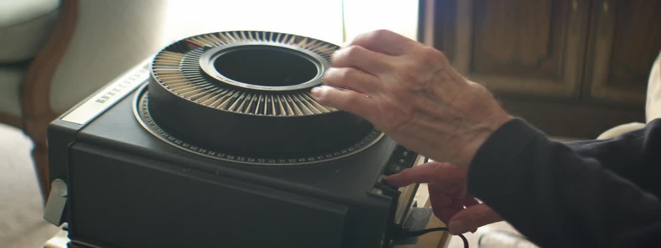 A man is playing a slide projector