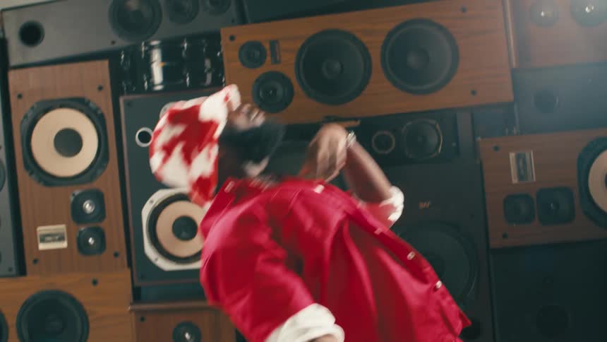 A man dancing in a room with speakers
