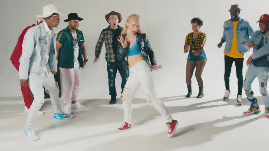 Group of young people energetically dancing in front of a white background