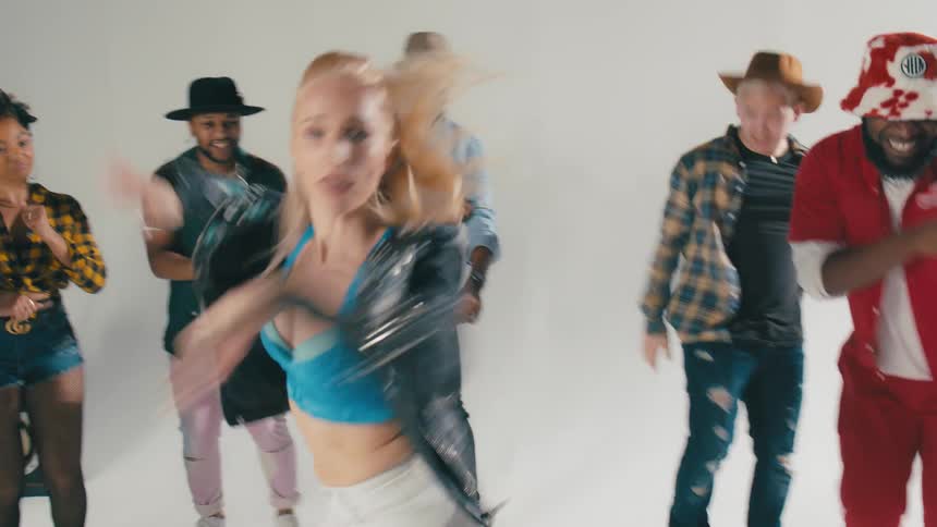 Men and women dancing with speakers and a wall in the background