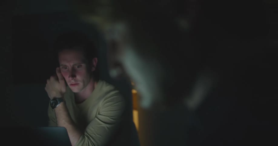 Two men are sitting in a room indoors