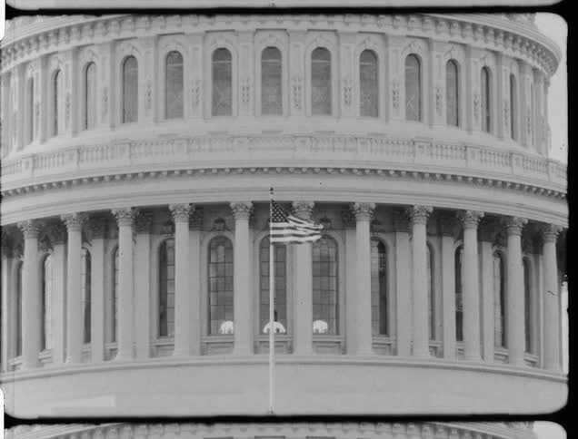 Vintage footage of american flag flowing in front of state capital