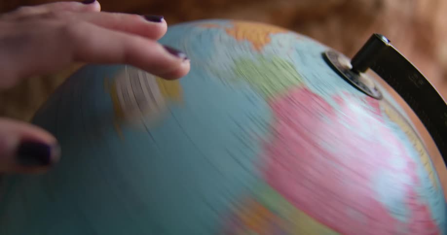 A person spinning a globe
