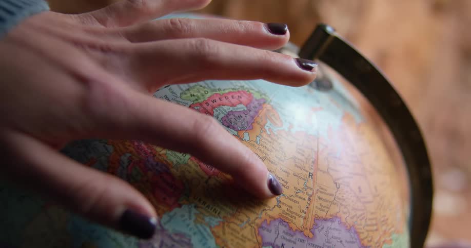 A woman that is spinning a globe