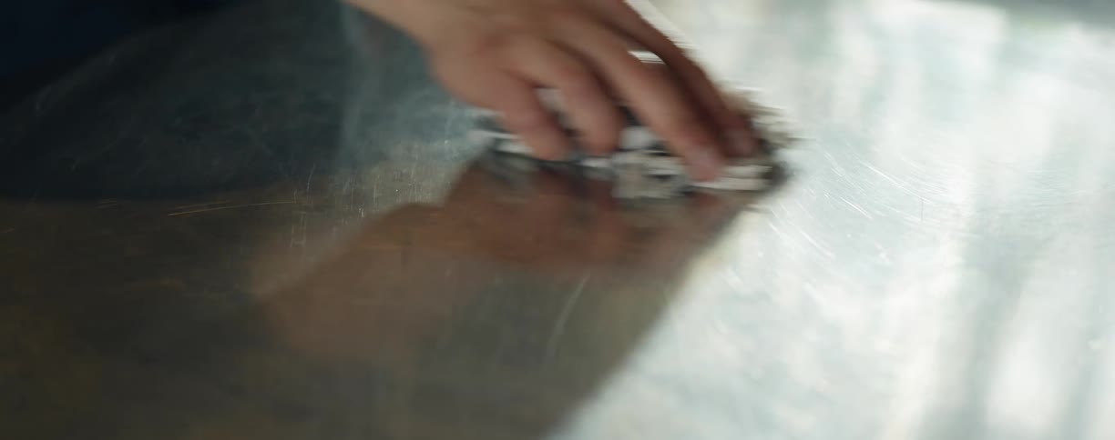 A person unses a rag to clean a metallic surface