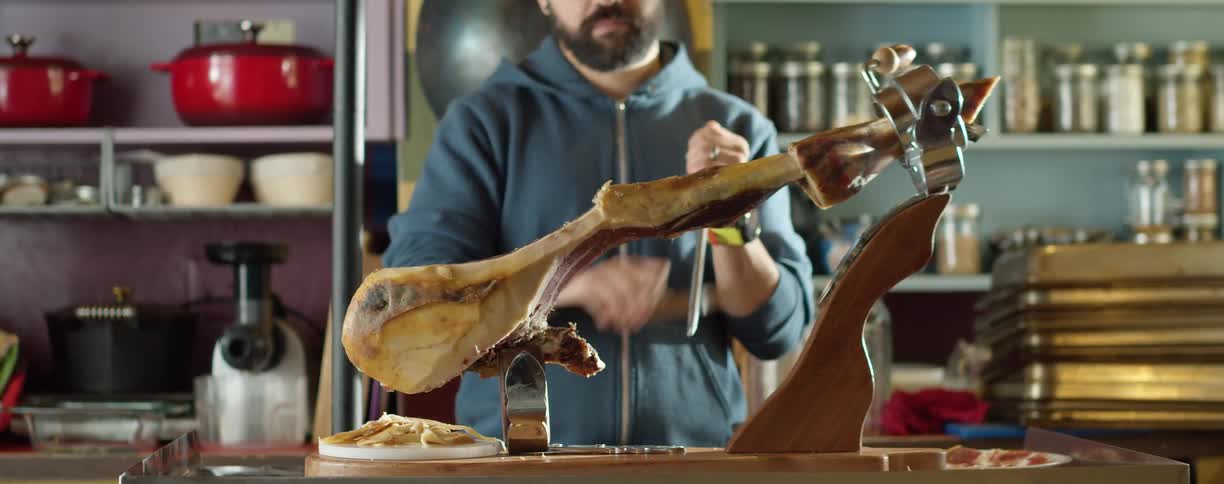 A man at home sharpens a knife before cutting meat