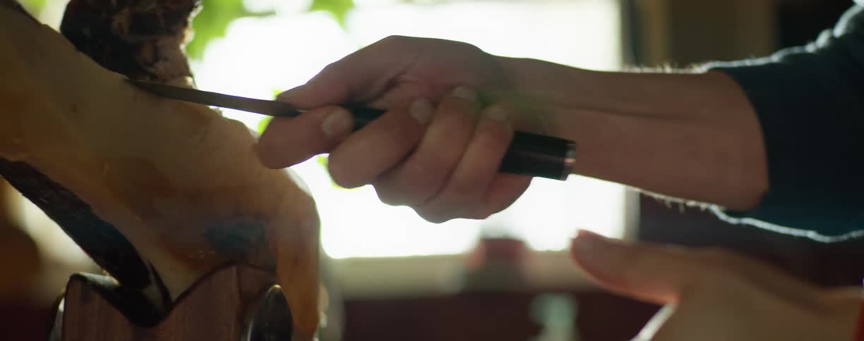 A man cutting meat in a kitchen