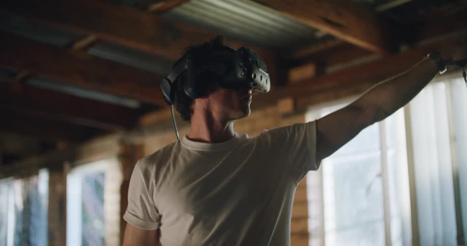 Man testing virtual reality goggles inside a dimly lit room