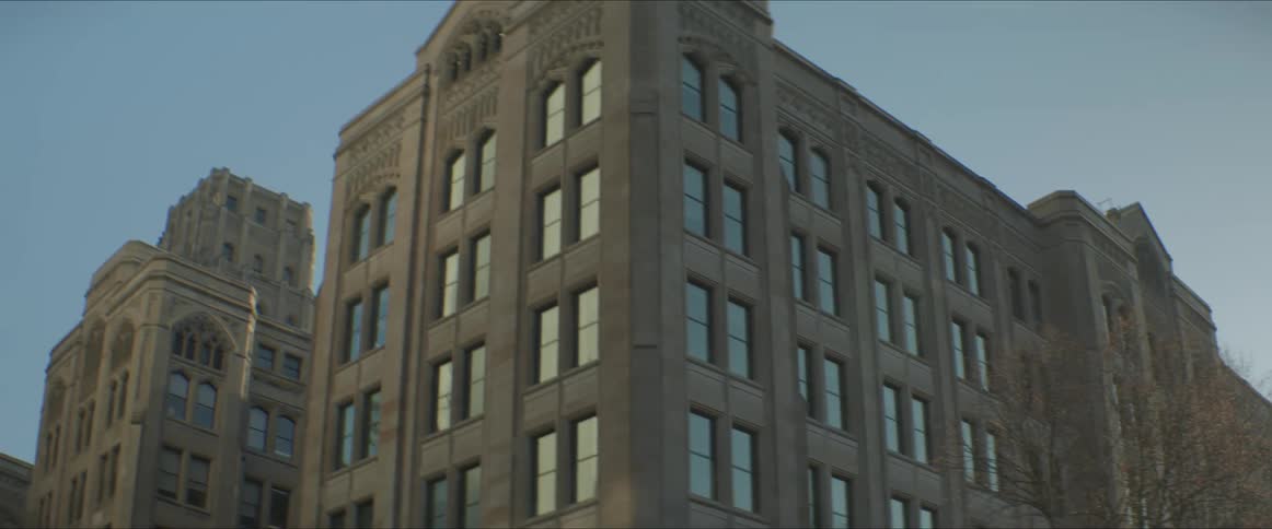 Facade of a tall apartment building in a city at sunset