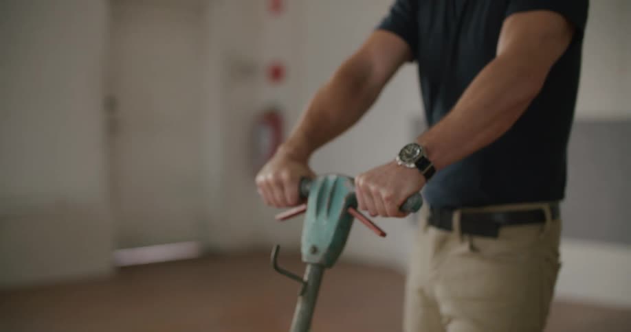 Man pushes and pulls machine across floor