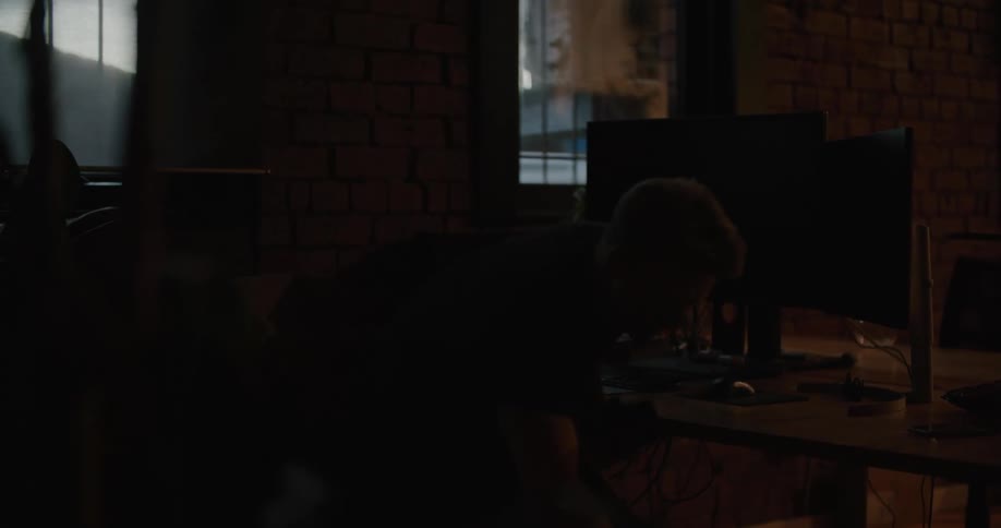 A man turns off his computer and leaves the office