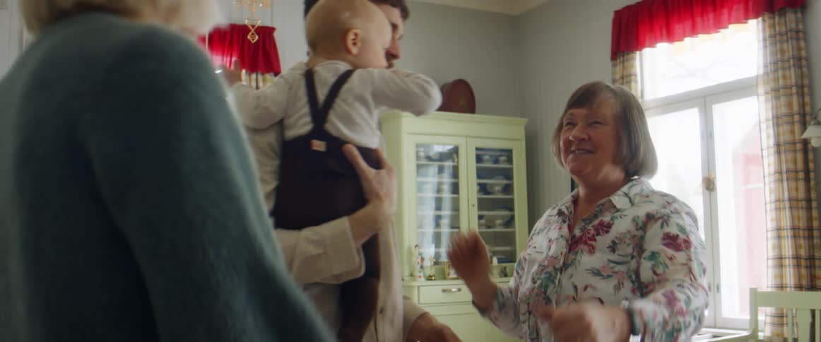 Grandmother greets family visiting with grandson