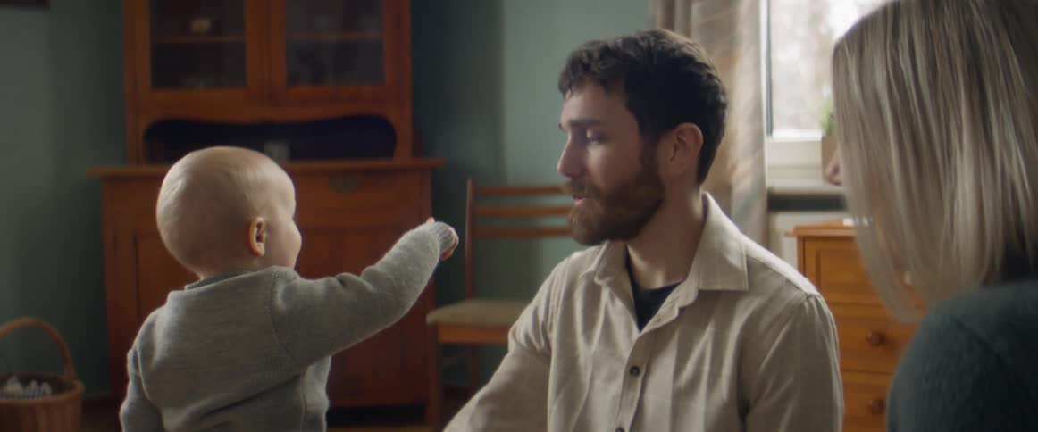 Father turns to look in direction toddler is pointing