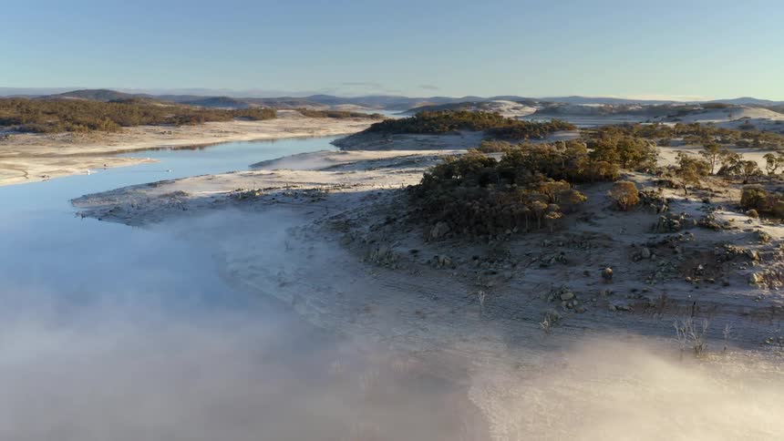 An aerial view of a river flowing through a hilly landscape in nature