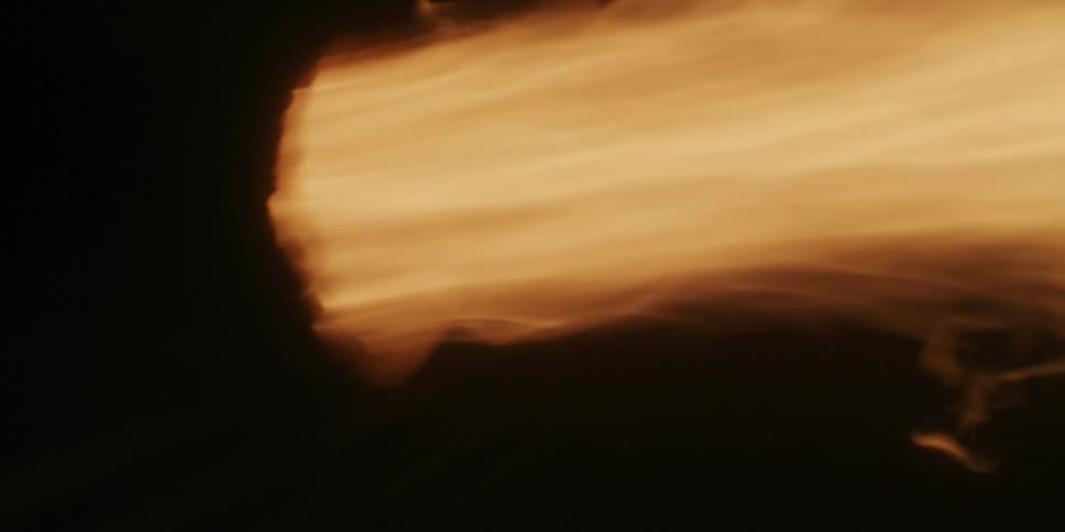 A flame is shooting out into the darkness