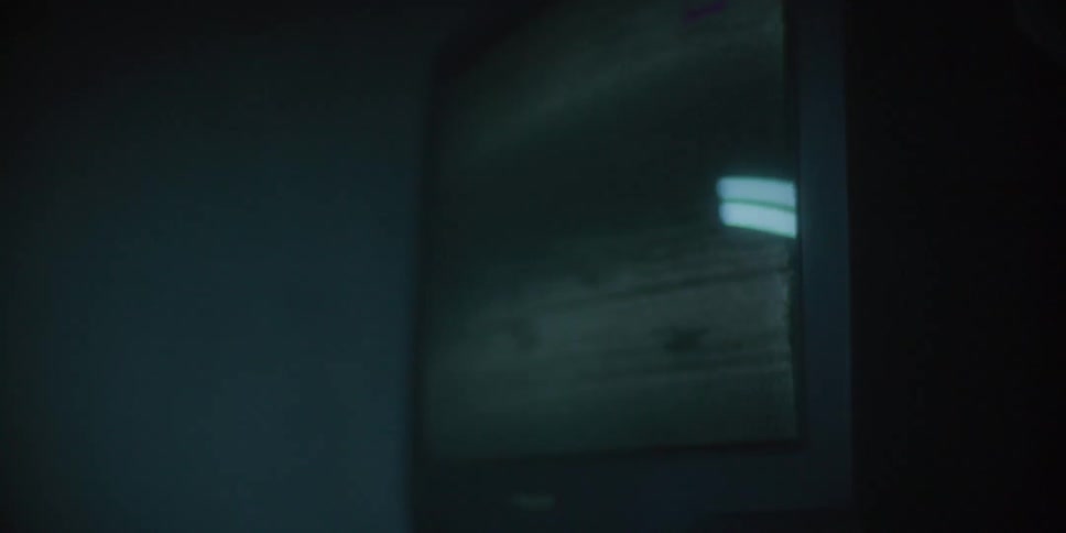 A child turns on a television causing static to display the screen in a dimly lit room