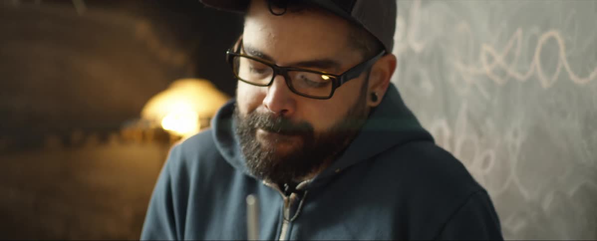 A hipster man plays drums and shimmies to the beat