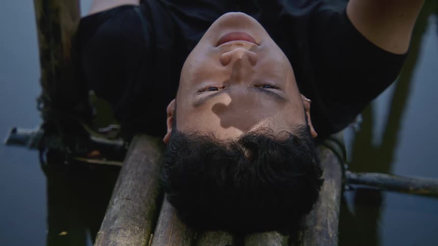 A man laying on a bamboo raft