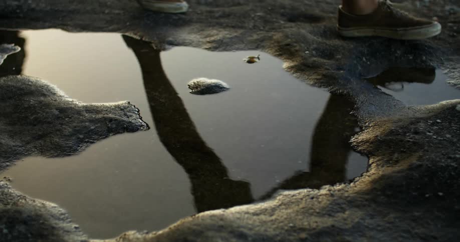 A person walking near a puddle