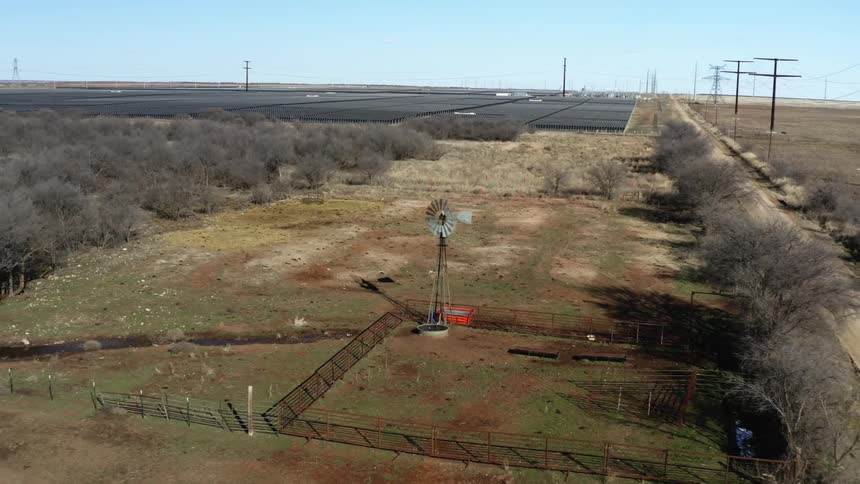 A wind turbine is spinning in a rural countryside