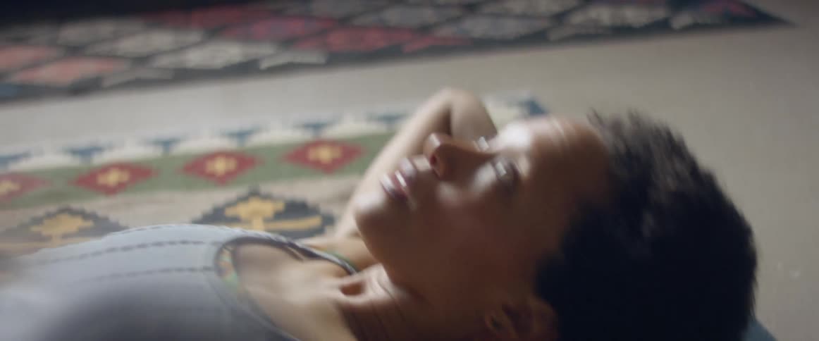 Woman with a grey top does half crunches in the living room at home