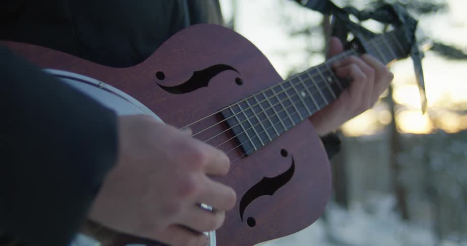 A person playing a guitar outside
