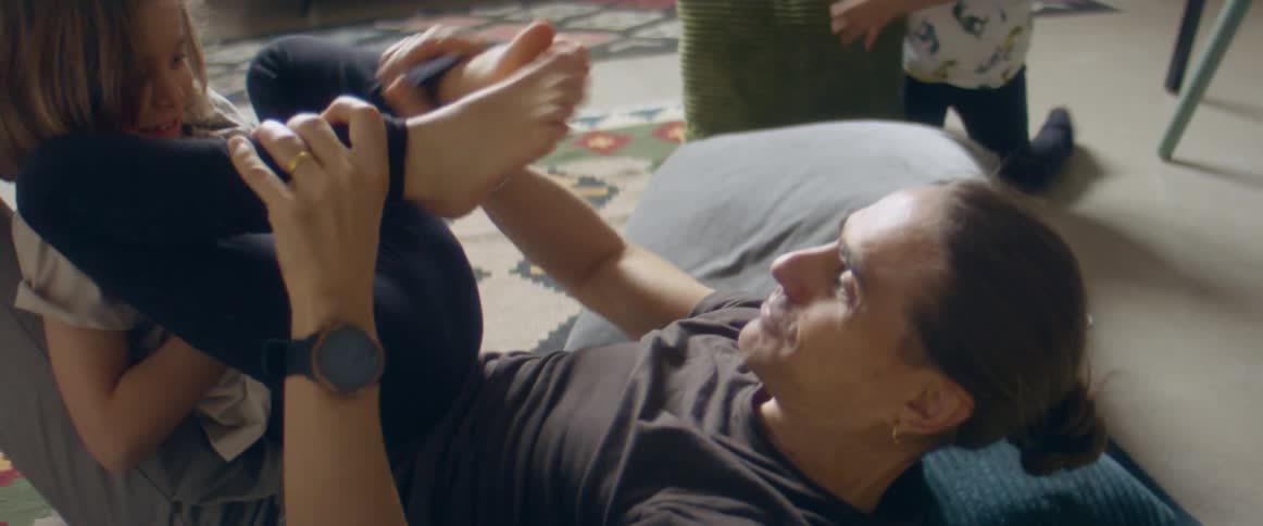 Father and son laying in the living room floor playing