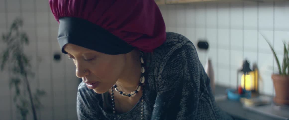 A woman talking while standing in a home kitchen