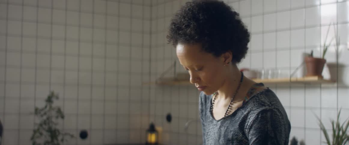 A woman dancing while cutting vegetables in a home kitchen
