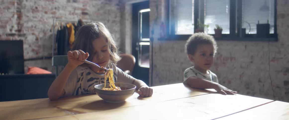 A boy eating food in a kitchen