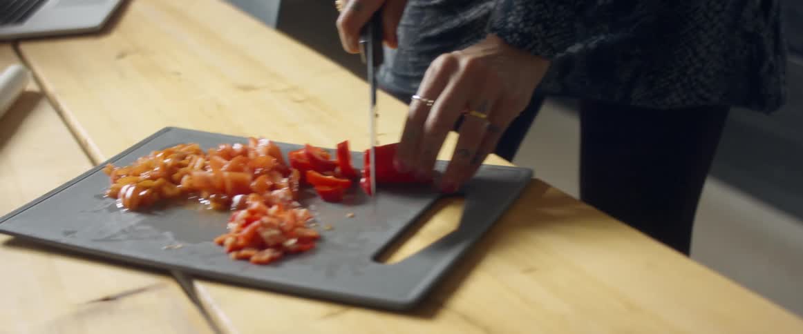 A woman at home cuts vegetables