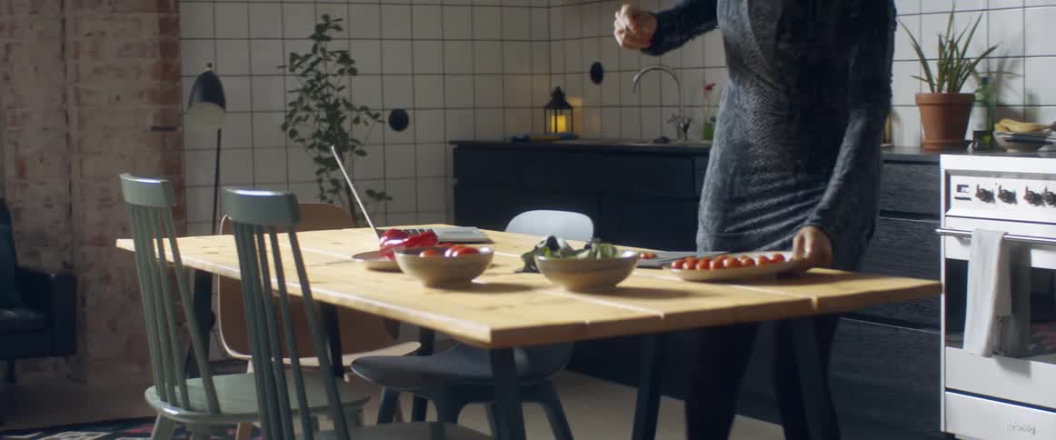 Woman dances while preparing food in the kitchen at home